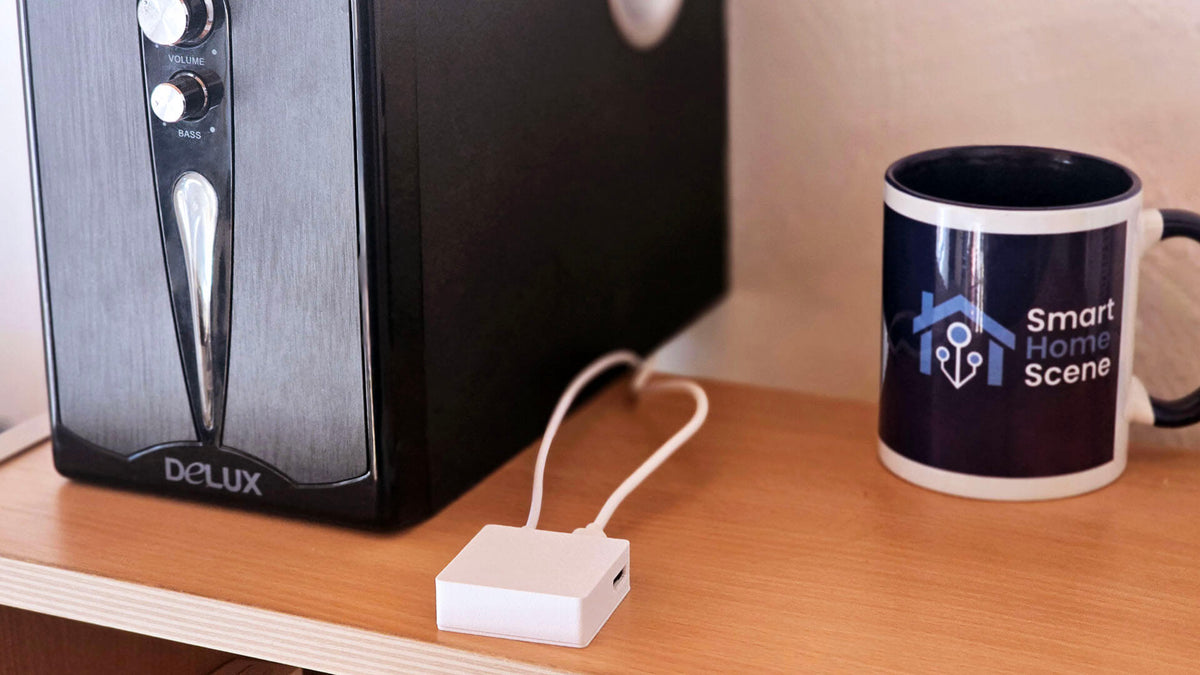 Apollo CAST-1 Audio Casting device connected by 3.5mm cable to powered speakers for local Music Assistant streaming
